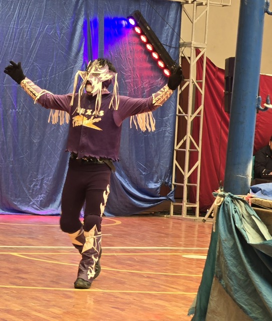 Lucha libre wrestler making a dramatic entrance with arms raised