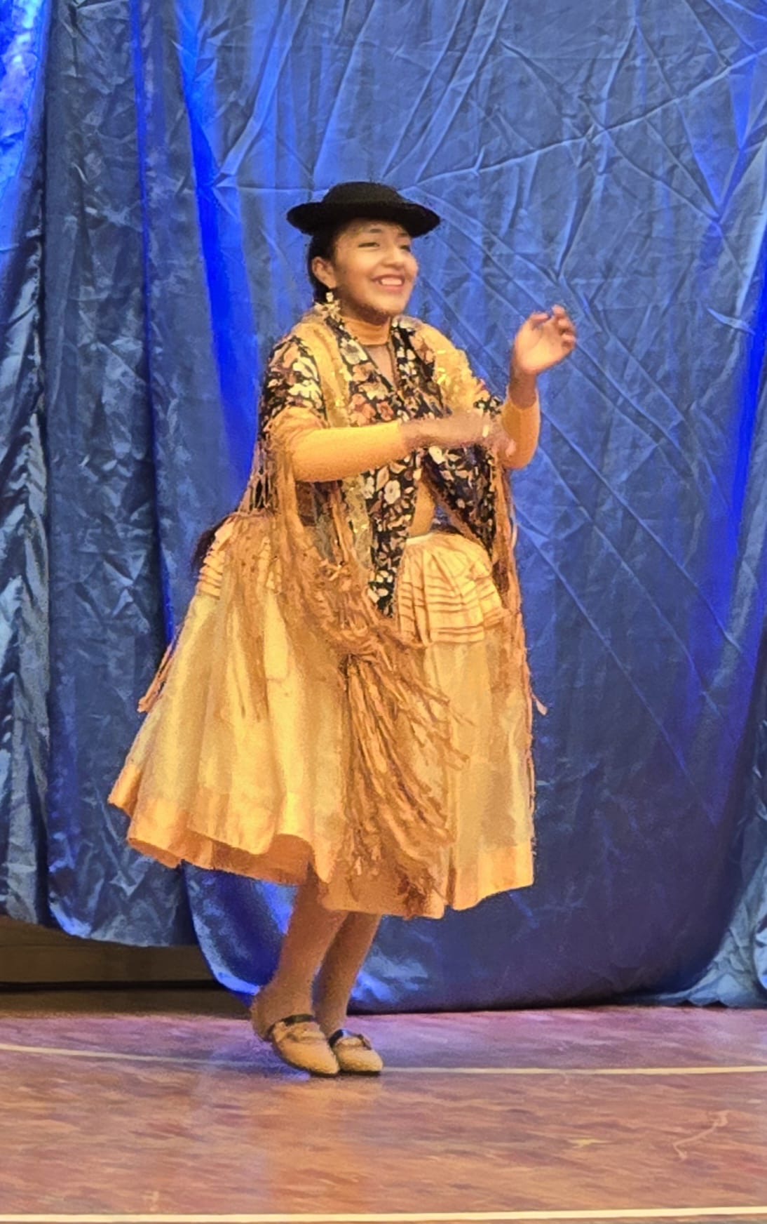 Cholita wrestler in golden pollera skirt and embroidered shawl
