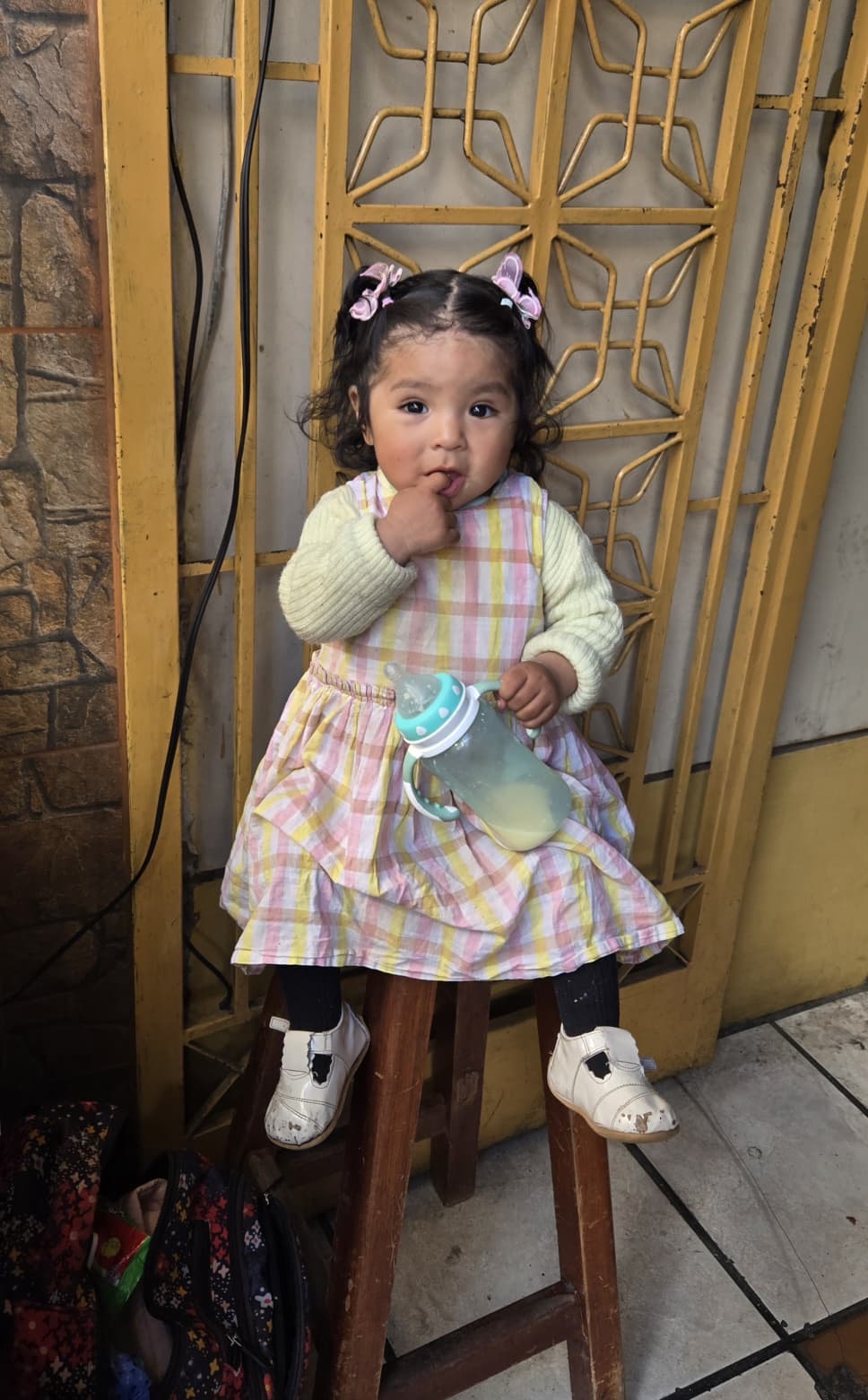 Adorable Bolivian toddler sitting on a stool in La Paz