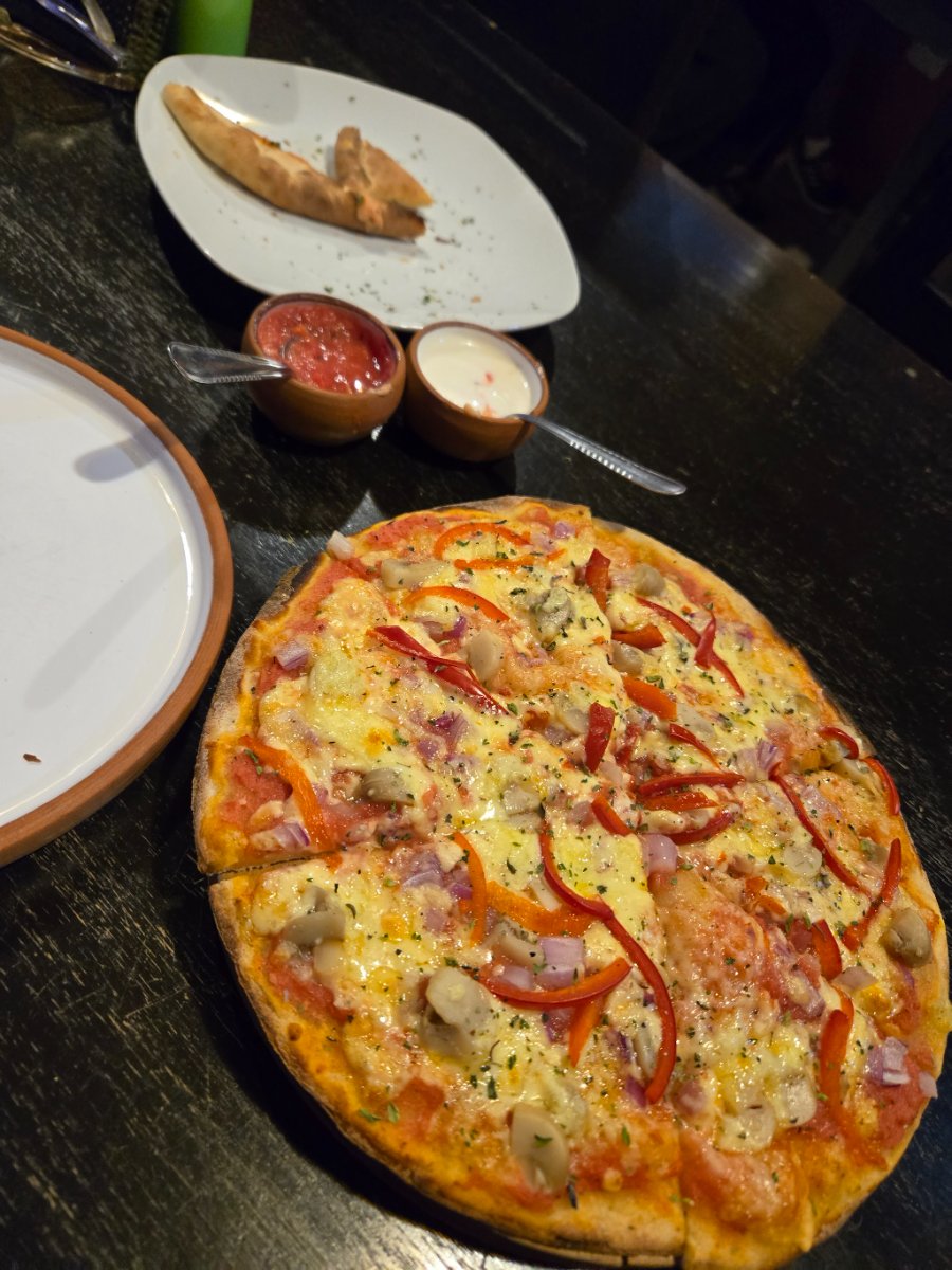 A pizza and other dishes on a table, likely a quick bite before the market